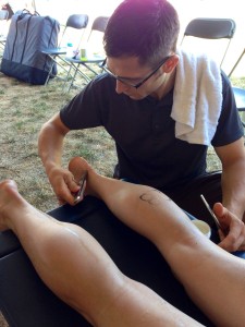 Treating heel pain with Graston Technique at the Hy-Vee Triathlon.