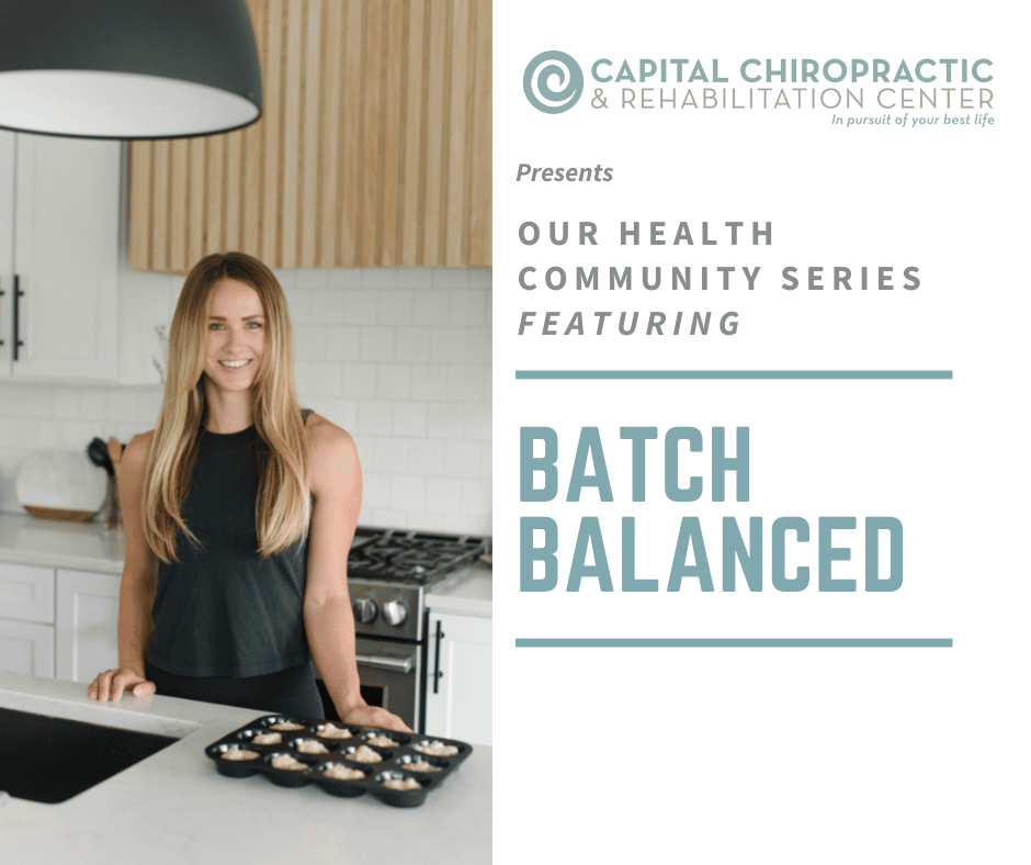 Megan, the owner of Batch Balanced, stands in a kitchen with a tray of muffins next to her on the counter.